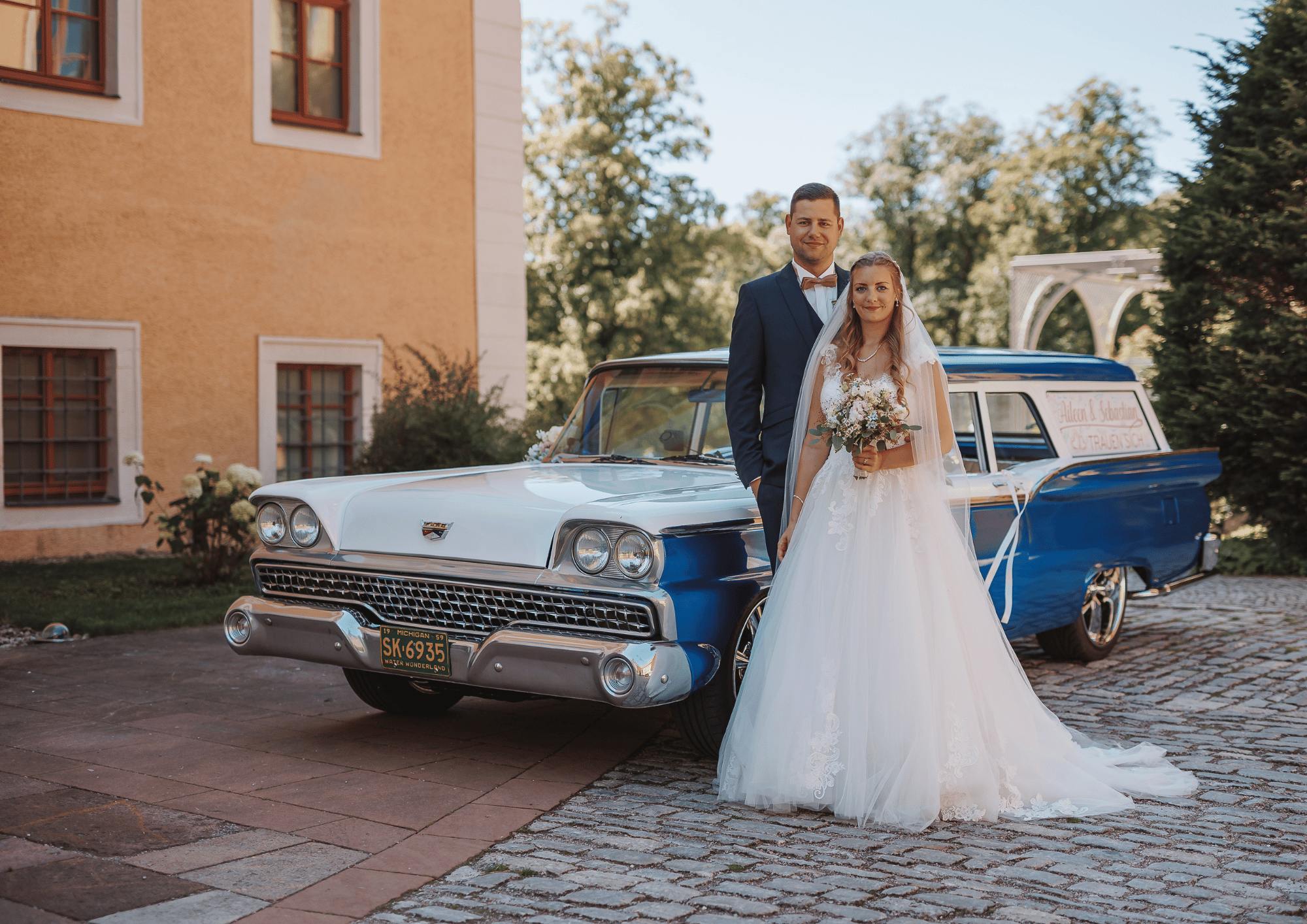Hochzeitspaar vor ihrem Hochzeitsauto auf Schloss Ettersburg